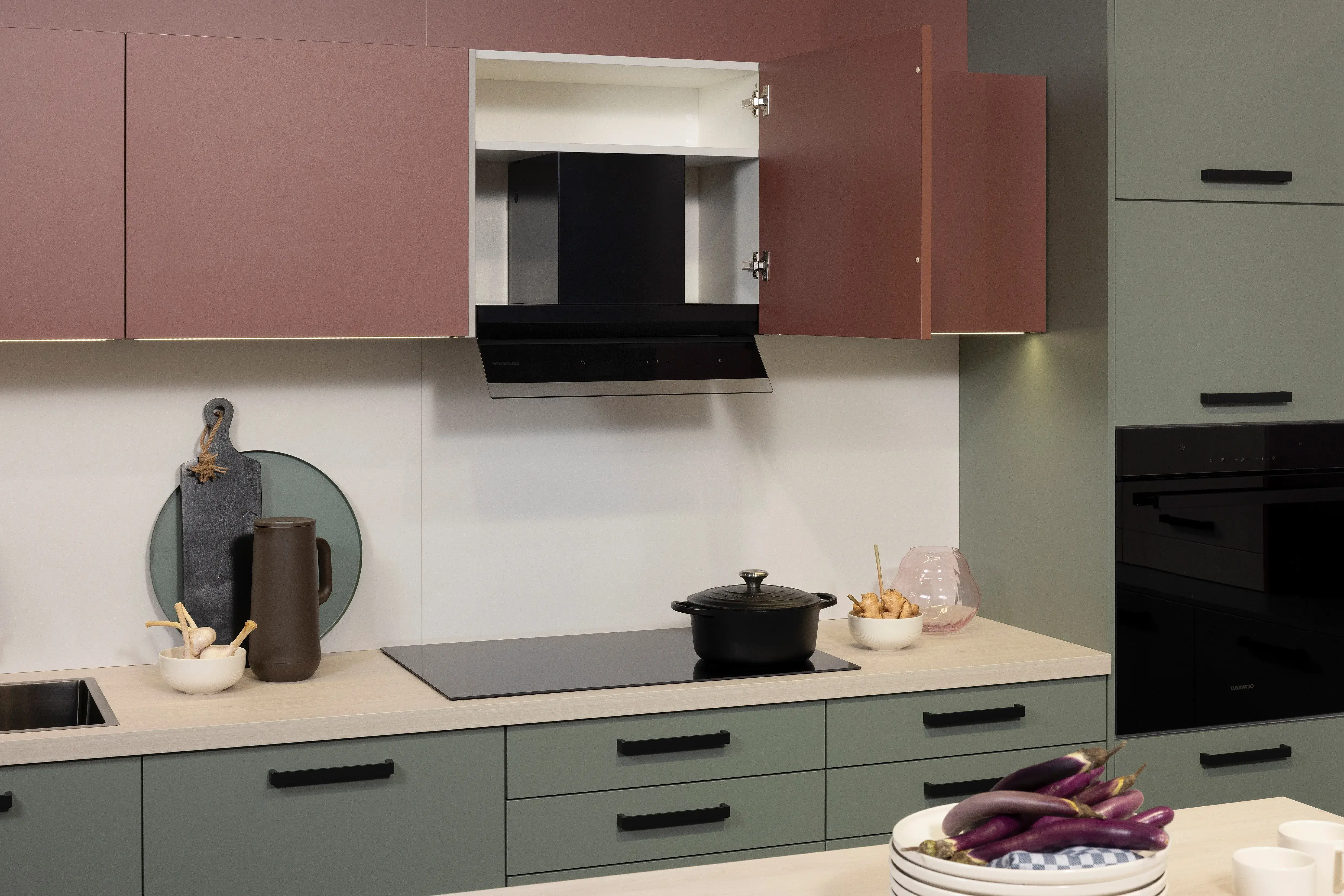 APL: White Oak Front: Pastell Eukalyptus Front: Pastell Oxidrot Korpus: Seidengrau Griff: Bügelgriff Geräte: Daewoo Armatur: Ukinox Spüle: Ukinox  Features: neue Fronten in Pastell kombiniert, neuer Haubenschrank für Dunstabzug, Handtuchhalter-Auszug, eingekofferte Wandschränke mit Klappe.